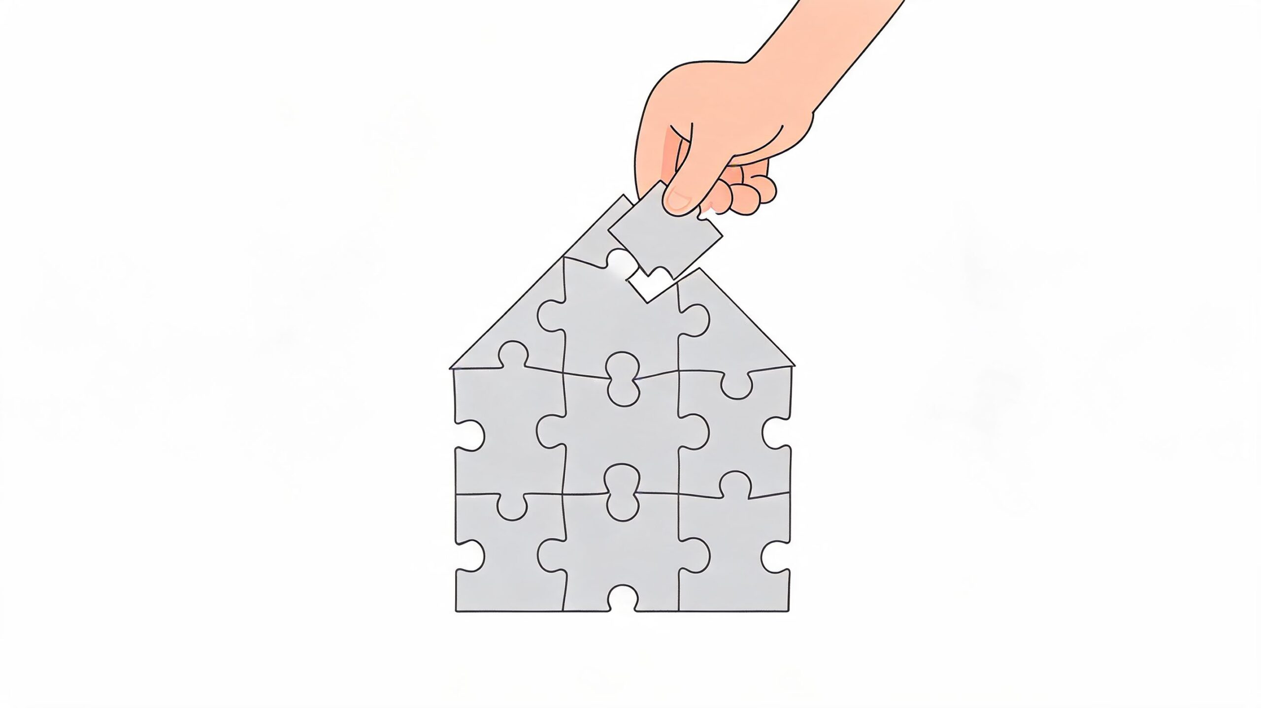 A hand placing the final puzzle piece to complete a house shape made of puzzle pieces.